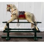 An early 20th century dapple grey rocking horse, padded saddle, leather tack, horse hair mane and