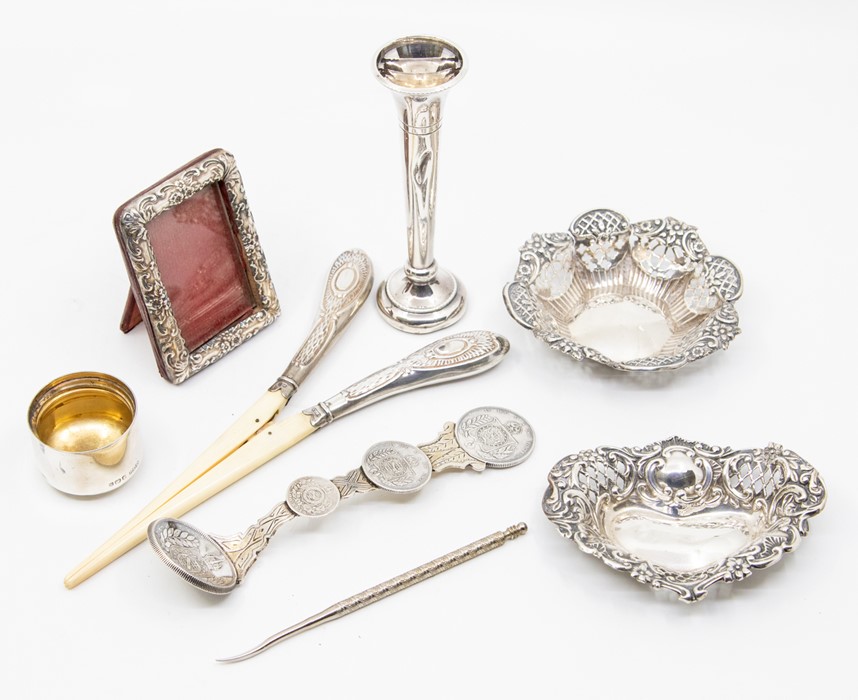 A collection of silver items to include two pin dishes, small bud vase, a small silver frame with