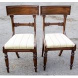A pair of William IV mahogany dining chairs, the curved top rail above a lotus carved bar back,