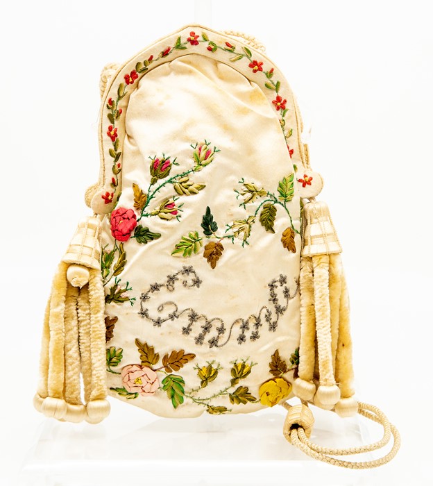 An 18th Century silk embroidered purse, of ovoid shape with arched mount, worked in coloured threads