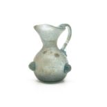 A Roman teal coloured glass jug with three berry decorative motifs to body