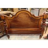 A Victorian mahogany double bedstead, the shaped back with barley twist columns and panelled centre,