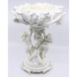 A late 19th Century blanc de Chine figural comport, floral bowl above central stem with putti on
