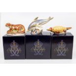 Three Royal Crown Derby paperweights with gold stoppers and in boxes, including dolphin, otter and