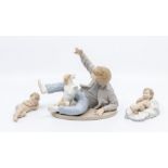 Three Nao figures including boy playing with dog and two young children figures