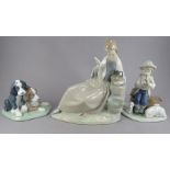 A group of three Nao porcelain figure groups. To include: a boy shepherd piping, two dogs and a
