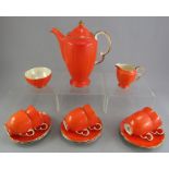 A Crown Devon coffee service decorated in an orange ground with gilded edges: coffeepot, sugar,