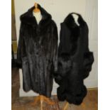 A very long length ranch mink fur coat in black with a hood, with a toggle fastener, fully lined. An