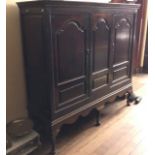 An early 18th Century oak linen press on stand, circa 1710, moulded cornice, above three panel