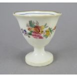 An early nineteenth century English porcelain egg cup, c. 1820. It is hand-painted with floral swags