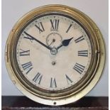 An early 20th century brass ship clock, circa 1920, circular form with roman numerals and subsidiary