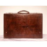 An early 20th Century leather suitcase, hinged by leather stitching, brass locks, leather handle,