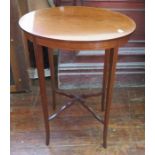 An Edwardian oval mahogany side table with inlay and cross-braced stretcher.