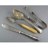 A small group of hallmarked silver to include: a knife, scoop, spoon and two pairs of tongs. 320g