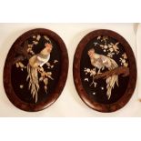 A pair of Meiji period Japanese shibayama wall plaques, circa 1870, red lacquered oval frame with