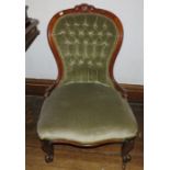 A Victorian upholstered button back low chair on caster cabriole front feet.