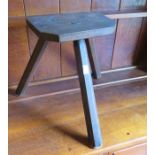 A nineteenth century pine three-legged milking stool. 36 cm tall.