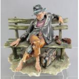 A late twentieth century Naples Capodimonte figure of a traveling gentleman resting on a bench. 22