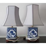 A pair of modern ceramic table lamps with shades decorated in blue and white in the Chinese