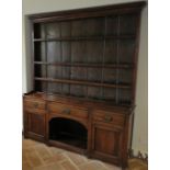 A Georgian oak dresser with three drawers, two doors and dog kennel. Brass handles. 170 cm wide. 207