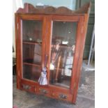 A nineteenth century wall hanging mahogany cupboard with two glazed doors and three drawers at the