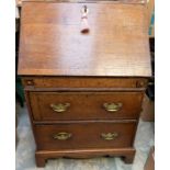 A Georgian oak bureau, of small proportions, the later replaced fall front enclosing drawers and