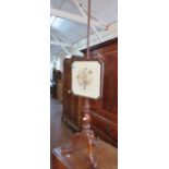 A Victorian mahogany adjustable fire screen on pole with needlework panel. 147cm tall.