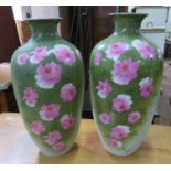 A pair of decorative ceramic vases with floral decoration. 44 cm tall. (2)  One damaged and stuck.