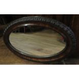 An oval hanging wall mirror with moulded detailing. 72cm wide In good overall condition.