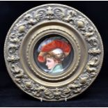 A pair of brass roundels set with painted porcelain plaques