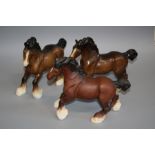 A Beswick cantering Shire, number 975, brown matt glazed, together with two gloss glazed models (one