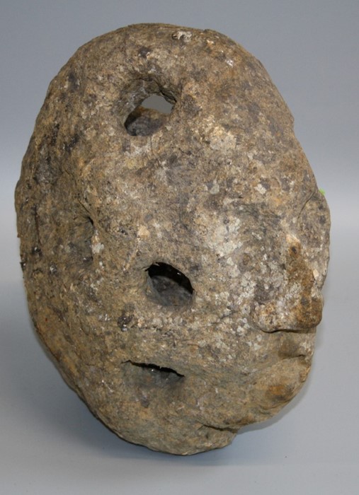 A quarried ironstone rock with machined cavities and sculptured facial features, 34 x 32 x 20cm