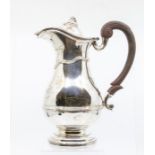 An Edwardian silver claret jug and cover, pear shaped with wavy rib upper section and central rib,