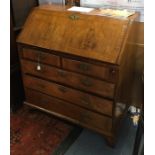 A George I and later walnut and cross banded bureau, circa 1720, the fall enclosing a fitted