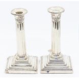 A pair of  Edwardian silver column candlesticks, acanthus scroll capital, on stepped bases, by