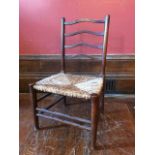 An Arts & Crafts child's chair, probably Cotswolds early 20th Century, serpentine bar splat, rush