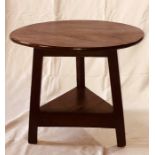 An 18th Century mahogany and pine cricket table, circular table top on a triangular base, raised