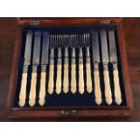 A late Victorian mahogany canteen of dessert knives and forks, carved ivory handles, steel blades,