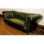 A traditional three seater Chesterfield settee, early 20th Century, green button back and studded