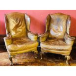 A pair of George III revival wing back armchairs, 20th Century, tan studded leather upholstery