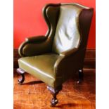 A 19th Century mahogany framed wing back armchair, green studded leather upholstery, serpentine top,