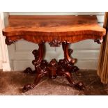 A William IV flame mahogany fold-over tea table, circa 1830, serpentine top, scroll mouldings to the