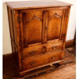 A tradtional oak cupboard, 20th Century, double ogee moulded panel doors, two short and one long