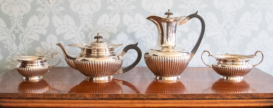 A George V four piece silver tea set, circular stop-fluted shapes with foliate borders maker