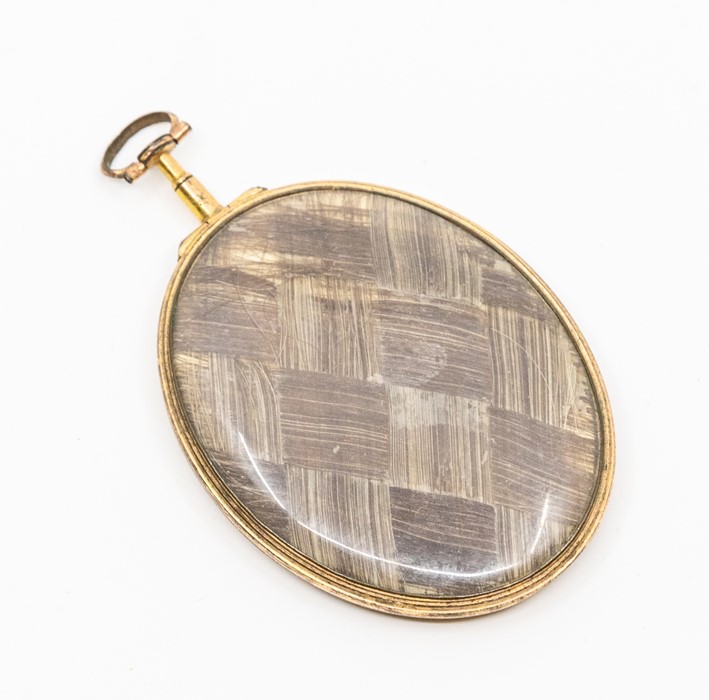 A George III oval mourning pendant locket, one side inset with plaited hair, the other of deep - Image 2 of 2