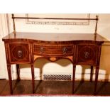 An Edwardian mahogany sideboard of Sheraton revival design, strung and inlaid, of serpentine form,