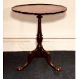 A George III mahogany tilt top table, circa 1820, piecrust moulded edge top above a turned