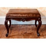 An early Victorian walnut dressing stool, circa 1850, in long form, rectangular leather seat,