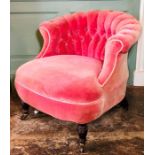 A late Victorian parlour tub chair, circa 1890, scroll top button back pink velvet upholstery,