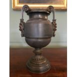 A 19th Century polished slate campana vase, bronze twin handles with Bacchus terminals, bronze